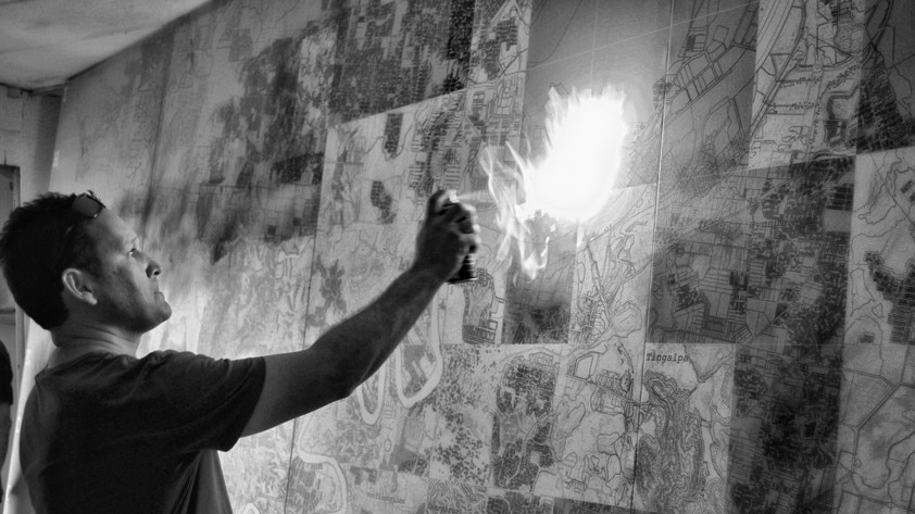 Kevin O'Brien burns the Finding Country map at the 13th International Architecture Exhibition in Venice, 2012. Photograph: Kevin O'Brien Architects, Philip Crowther