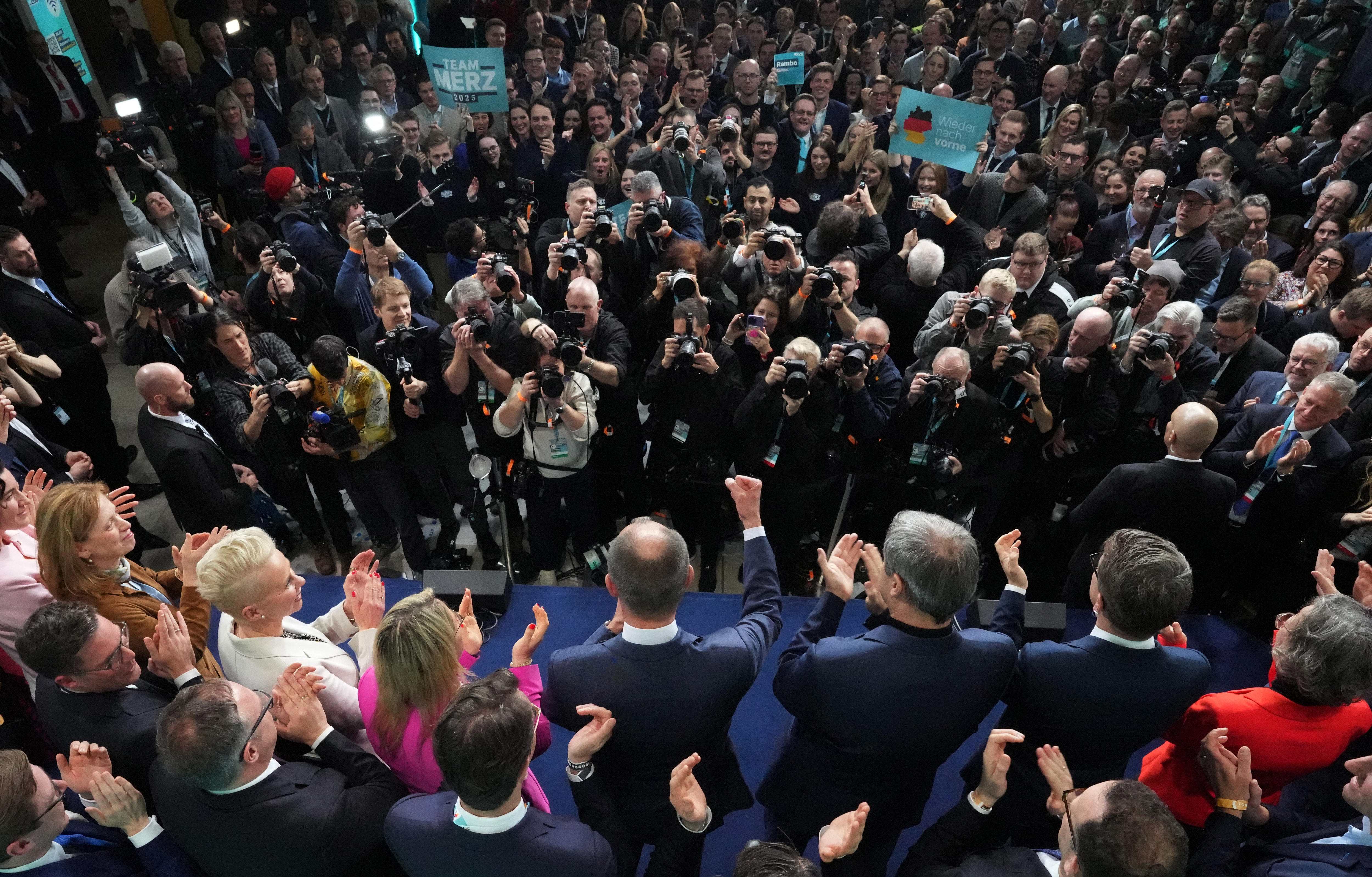 Photographers click pictures of people standing on a stage