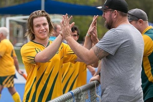 A 22-year-old man high fives his father after a hockey match on the Sunshine Coast.