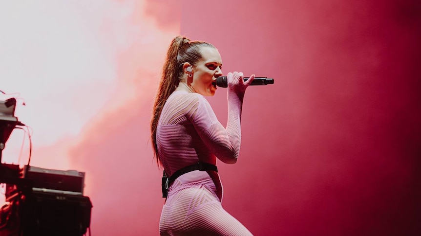 Tove Lo performs on stage at Splendour in a pink mesh bodysuit and with a long ponytail.