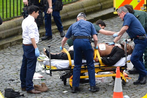 The London terrorist attacker is treated by emergency services while police look on in London on March 22, 2017