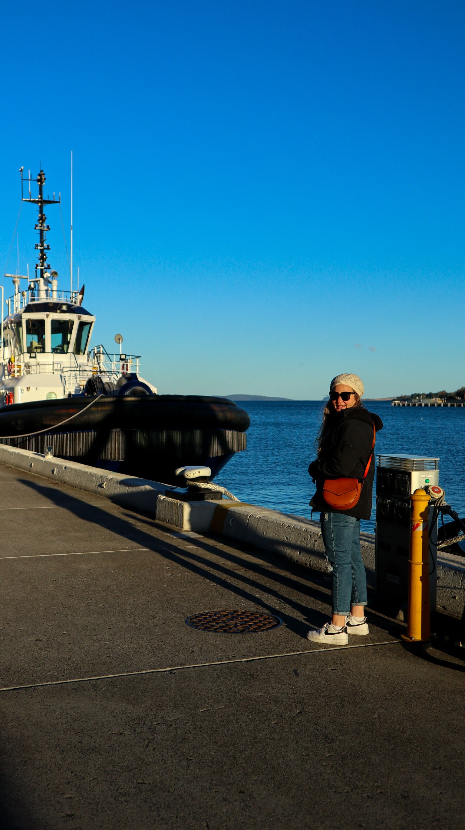 Woman stands in front of Hobart harbour