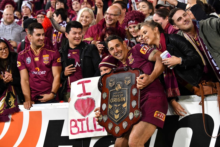 Billy slater holds the State of Origin shield as he celebrates with Queensland supporters.