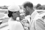 A black and white photo of Harry and Meghan cuddling Archie Harrison