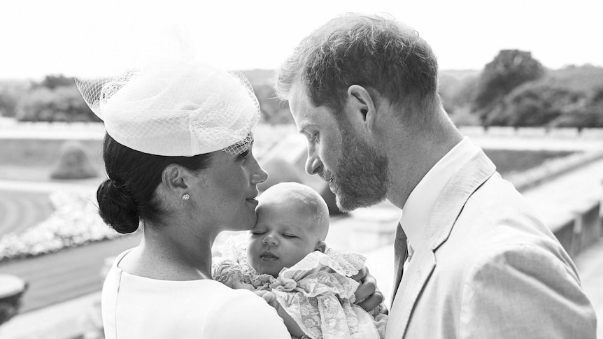 A black and white photo of Harry and Meghan cuddling Archie Harrison