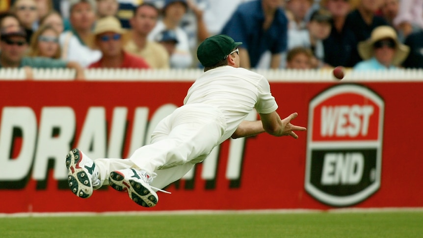 Glenn McGrath est horizontal dans les airs alors que le ballon s'approche de ses mains tendues