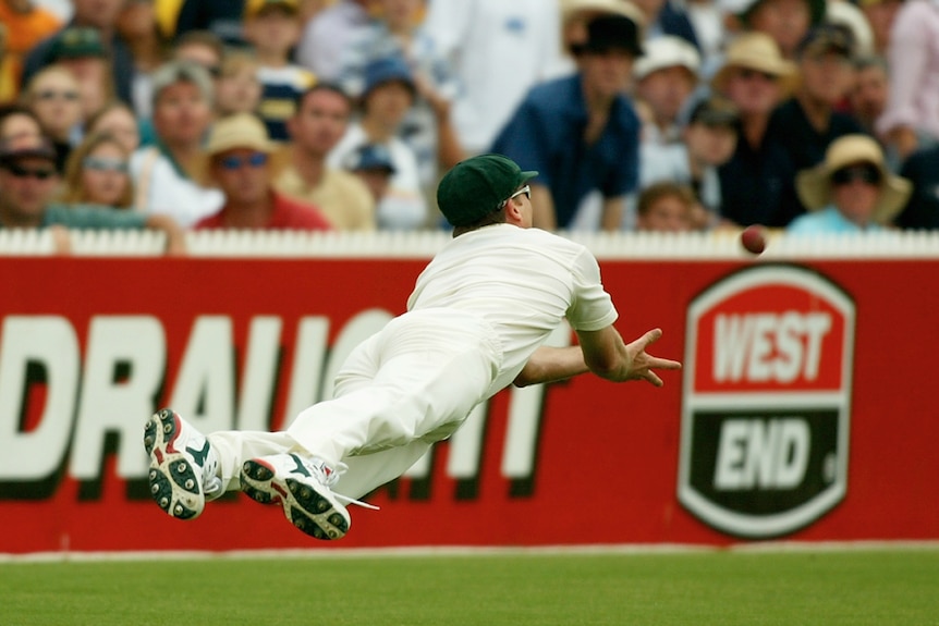Glenn McGrath is horizontal in the air as the ball approaches his outstretched hands