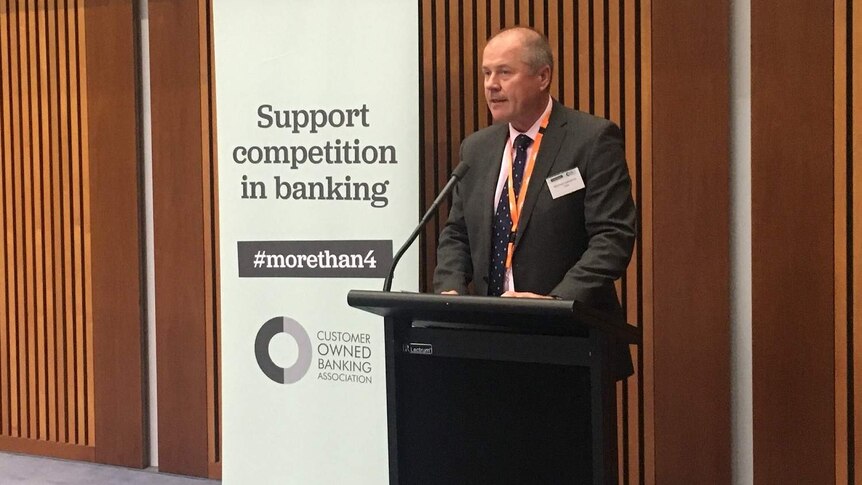 Mike Lawrence, CEO of the Customer Owned Banking Association (COBA), stands behind a podium and addresses an audience