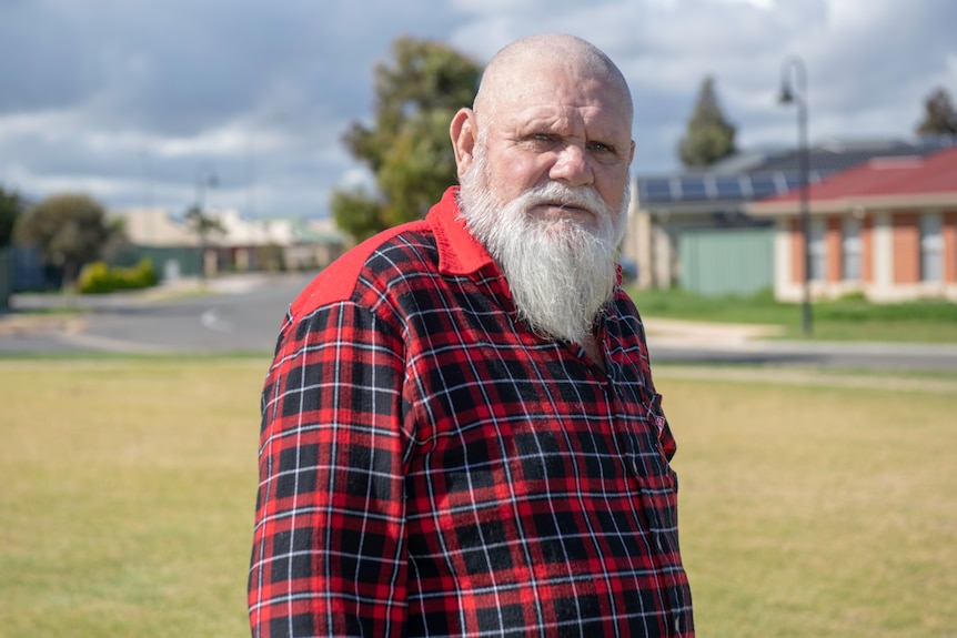 A man looks at the camera from a side-on position.