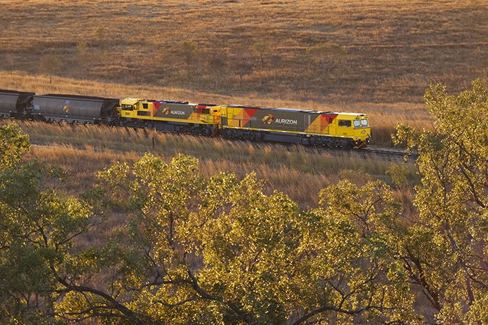 An Aurizon train passing through countryside/