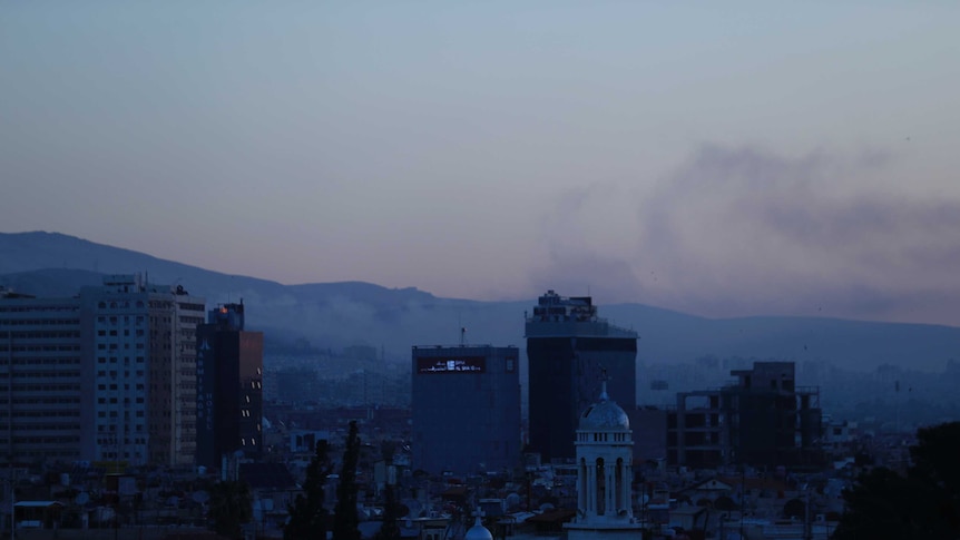 Smoke rises over the Damascus skyline in Syria