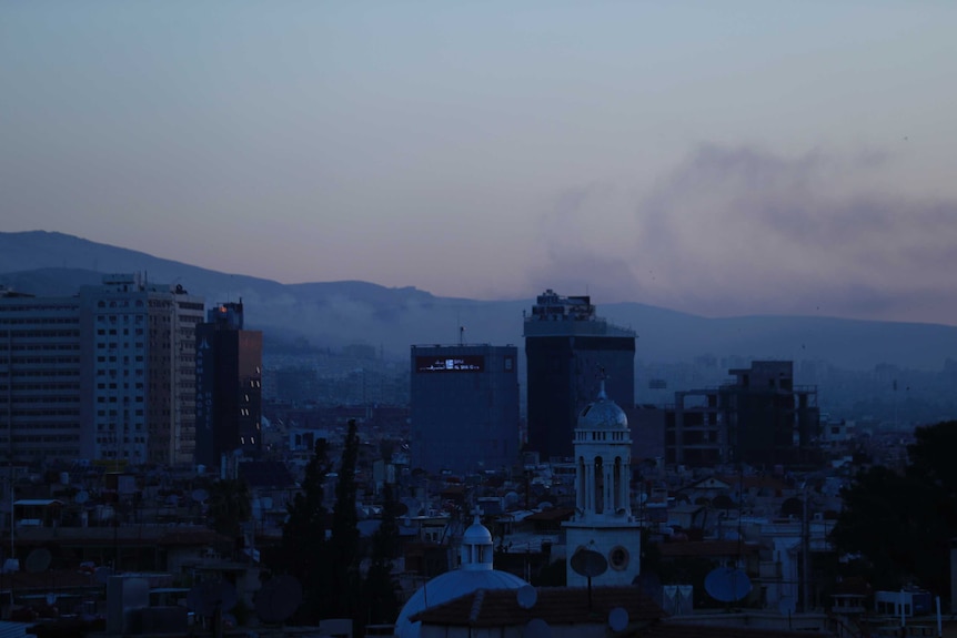 Smoke rises over the Damascus skyline in Syria