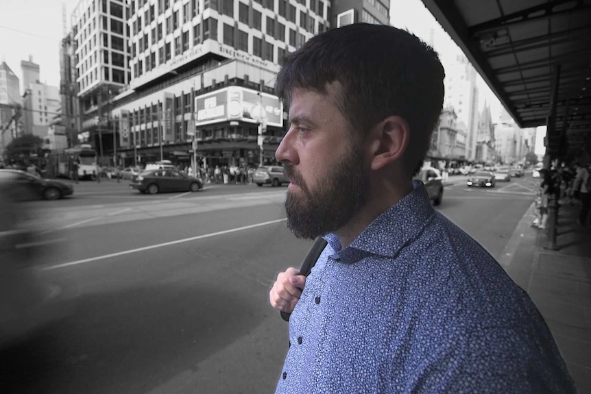 David Gardner stands at a busy city intersection.