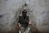 A man cools off from a public tap after filling bottles during intense hot weather in Karachi, Pakistan