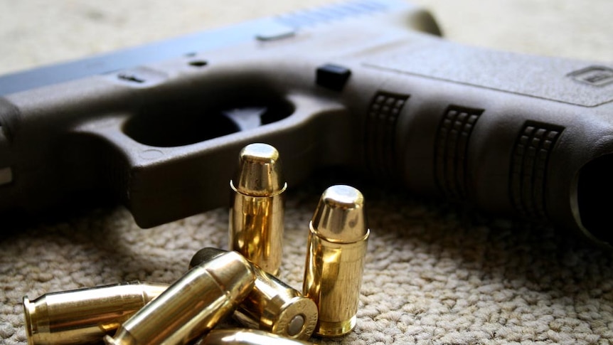 A Glock hand gun and bullets.