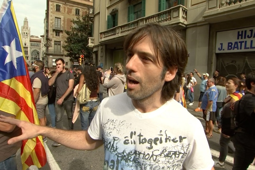 A male protestor stands on a street in Barcelona.