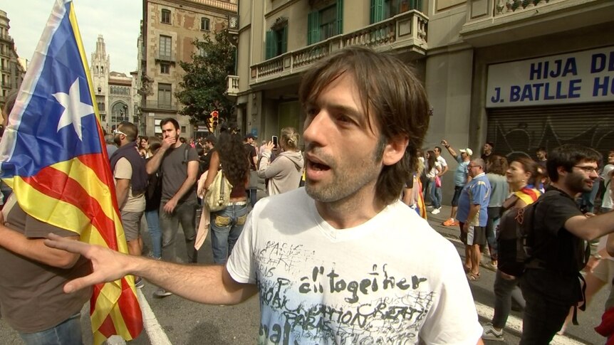 A male protestor stands on a street in Barcelona.