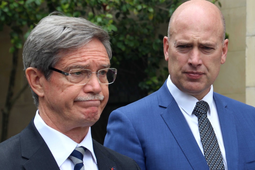 Mike Nahan presses his lips together as Dean Nalder looks on.