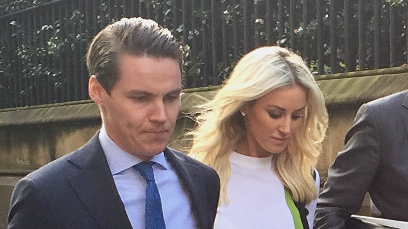 Oliver Curtis and Roxy Jacenko with downcast eyes, walk on the street.