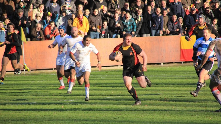 Alain Miriallakis makes a break up field in a rugby match.