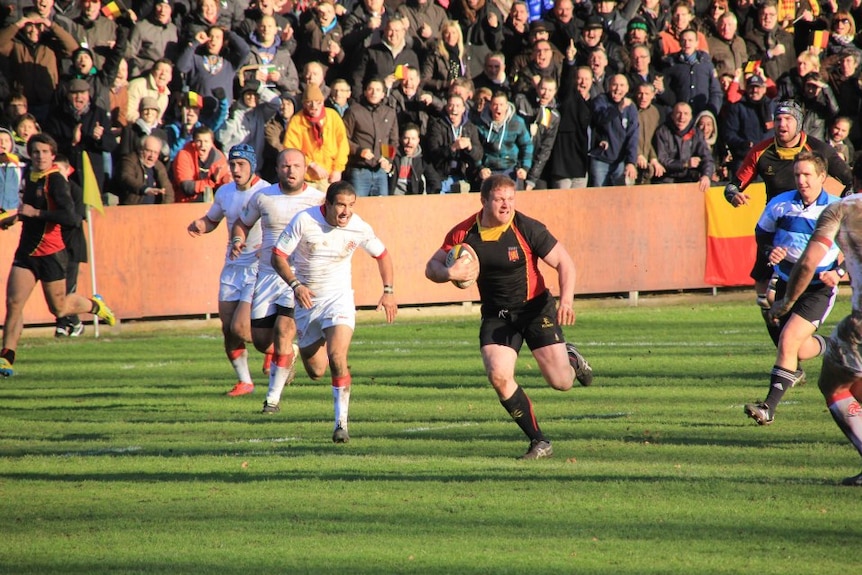 Alain Miriallakis makes a break up field in a rugby match.