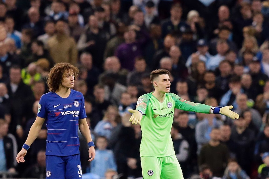 Kepa Arrizabalaga stands with his arms outstretched with David Luiz standing behind him