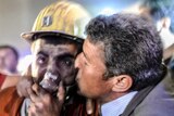 A miner celebrates with his father (R) after an explosion and mine collapse in Manisa