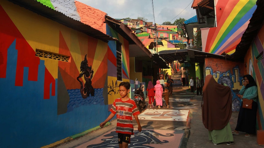 Residents walk through a colourful street in Wonosari Village, in Semarang Central Java, Indonesia. May 2017.