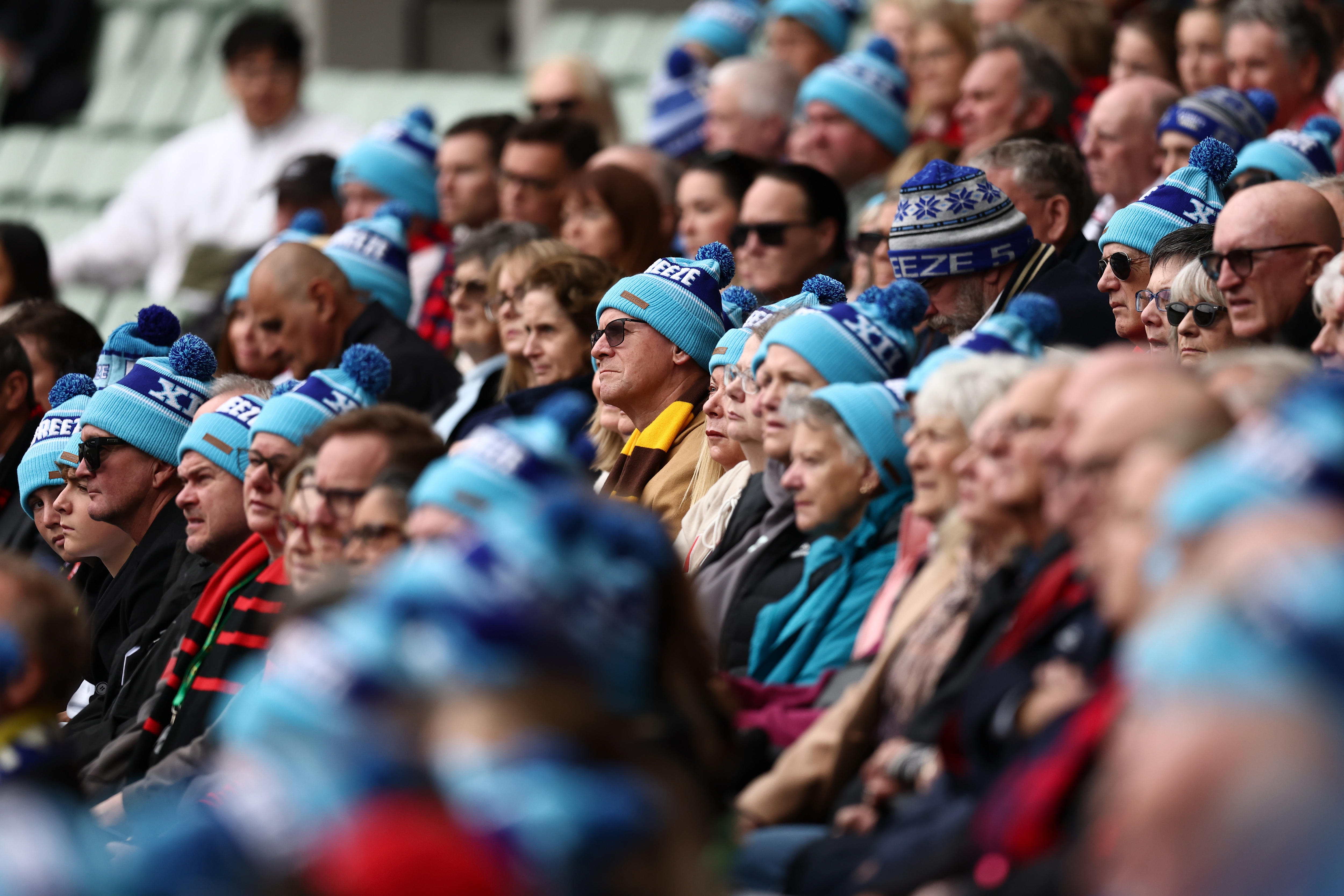 The crowd in the MCG stands at Neale Daniher's funeral wears Big Freeze beanies