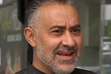Essendon cafe owner Sam Khoury, wearing a black chef's top, outside his cafe.