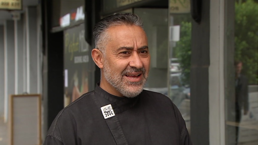 Essendon cafe owner Sam Khoury, wearing a black chef's top, outside his cafe.