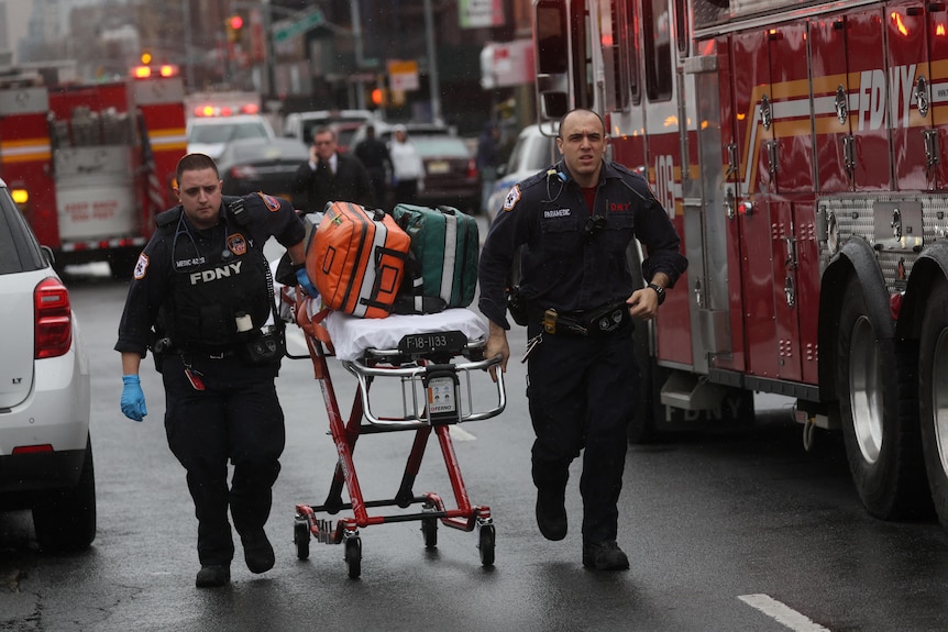 Paramedics run with a stretcher on a Brooklyn road