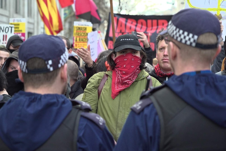 Protesters hold placards with fascist messages.