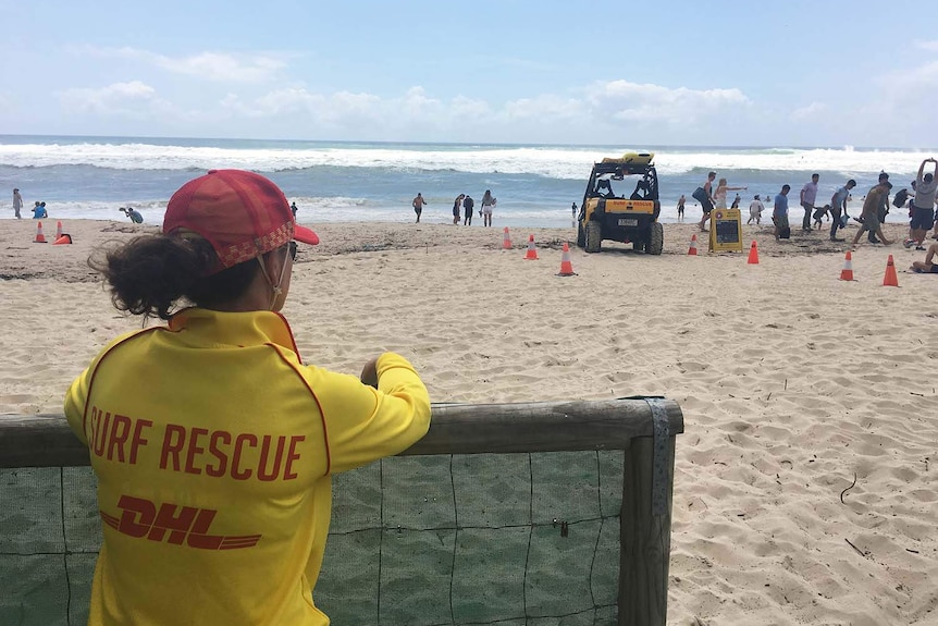 Lifesaver watches wild surf at closed Burleigh Beach on Queensland's Gold Coast on February 18, 2018.