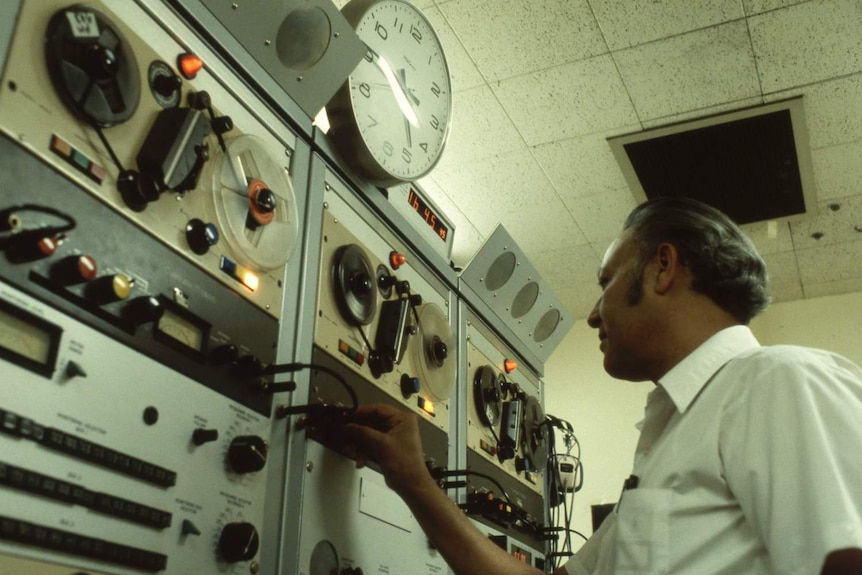 Archival image of unidentified man with tape recorders and other studio equipment at the ABC in the 1980s.