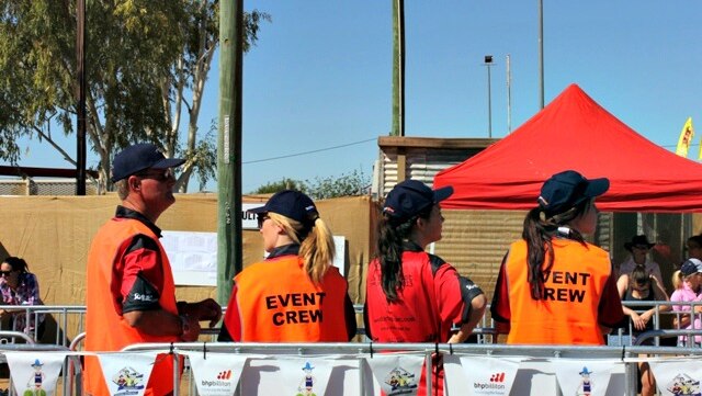 Four people in bright orange vests, with 'event crew' written on their backs.