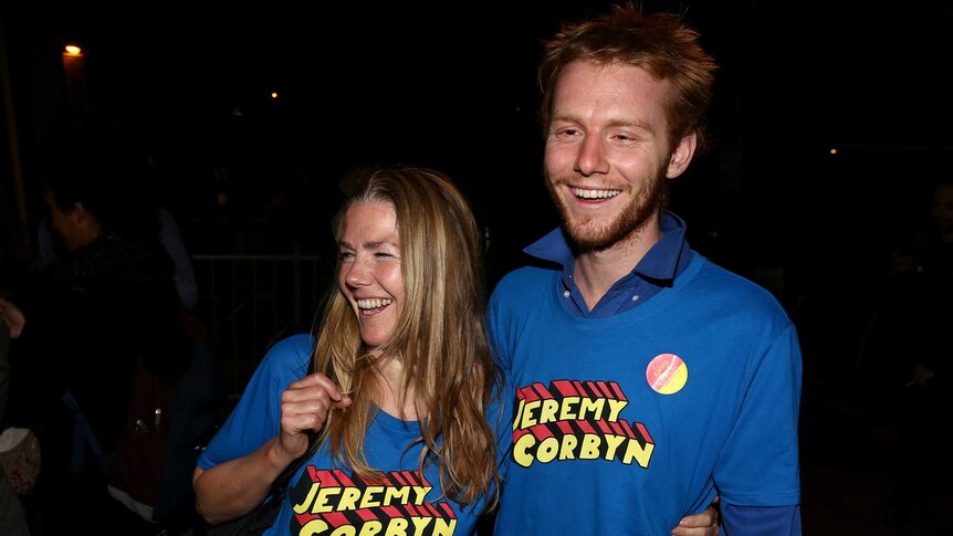 Supporters of Jeremy Corbyn wear blue shirs with "Jeremy Corbyn" emblazoned in red and yellow block text
