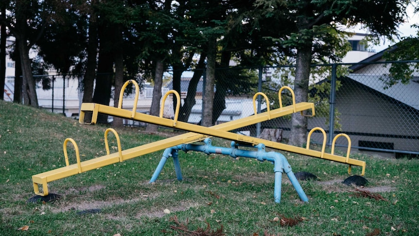 An empty yellow seesaw in a children's playground