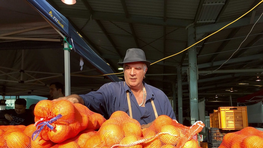 Mick Auddino stands over a bunch of fruit