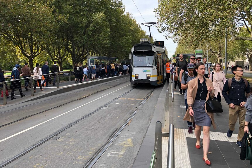 Crowds fill tram platforms at the Art Centre stop.