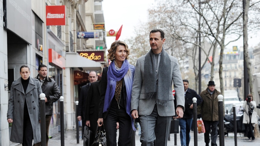 Syrian president Bashar al-Assad and his wife Asma walk down a Paris street.