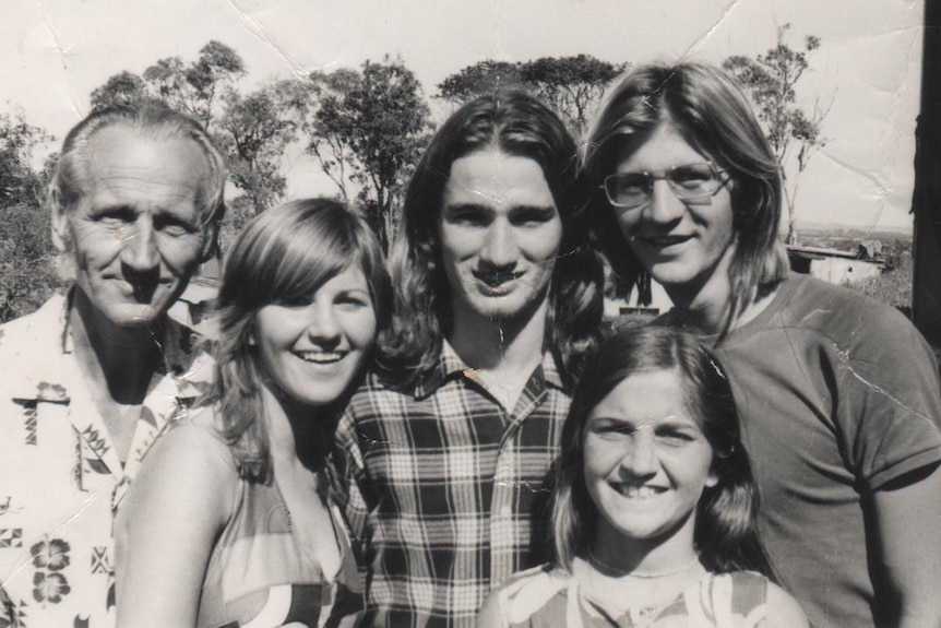 black and white photo of dad with teenage children