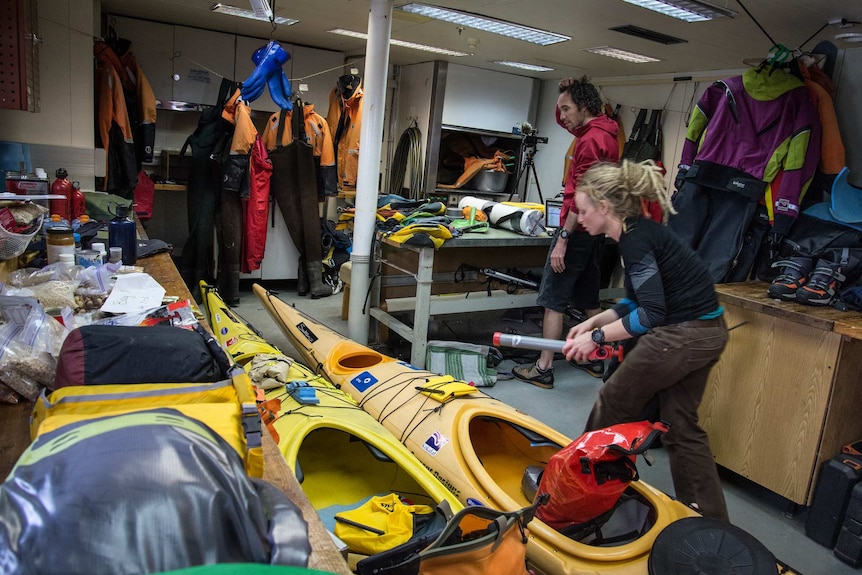 Sophie and Ewan and their two kayaks and piles of their supplies in a store room of the ship dropping them off.