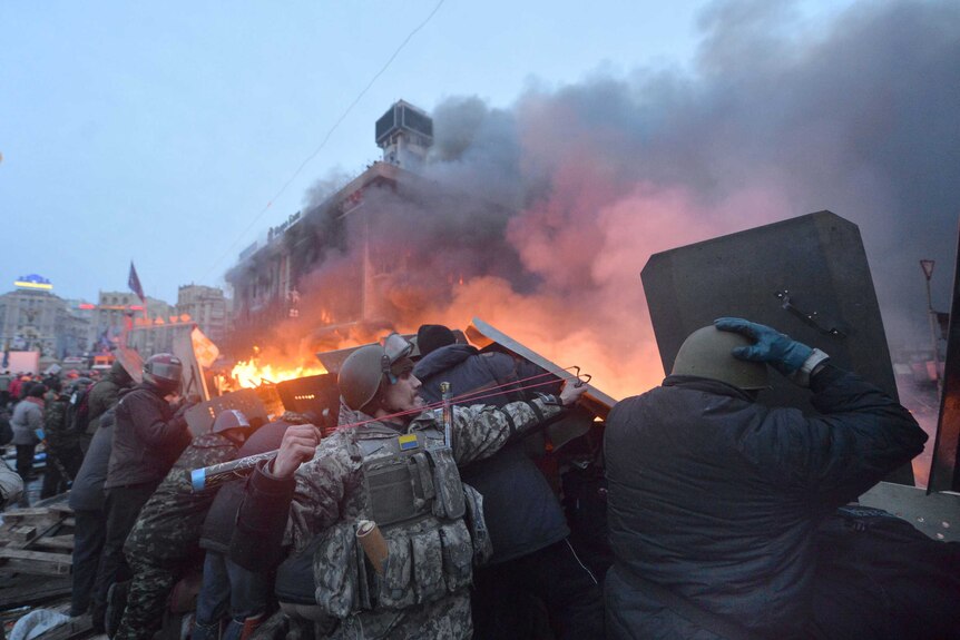 Ukrainian anti-government protester uses a slingshot