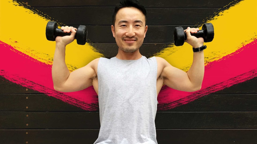 A man holds dumbbells in his hands raised up to head height for a story about weight lifting health benefits.