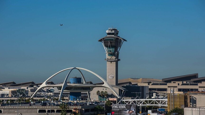 Los Angeles Airport pictured from afar with rows of multi-storey carparks in the foreground, its control tower behind