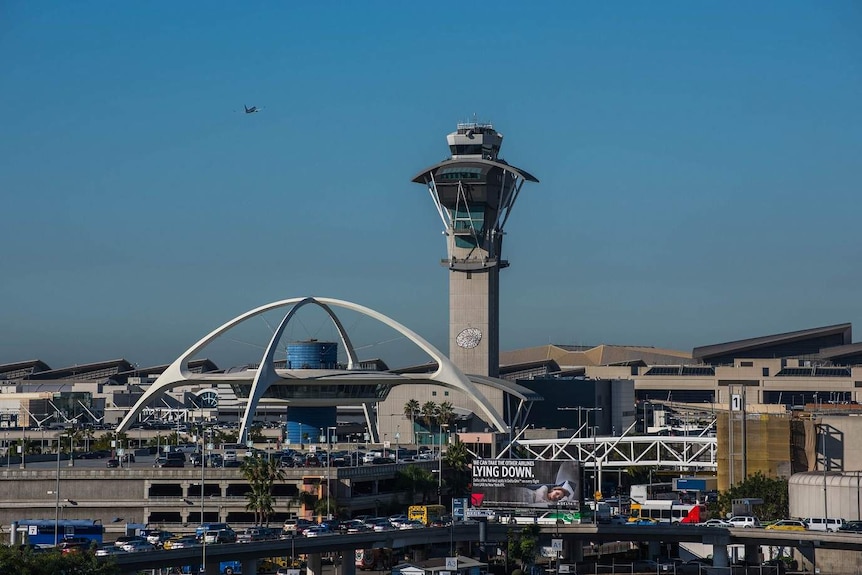Los Angeles Airport pictured from afar with rows of multi-storey carparks in the foreground, its control tower behind