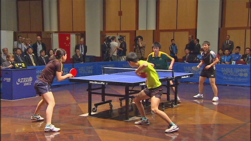 Four table-tennis players during a match
