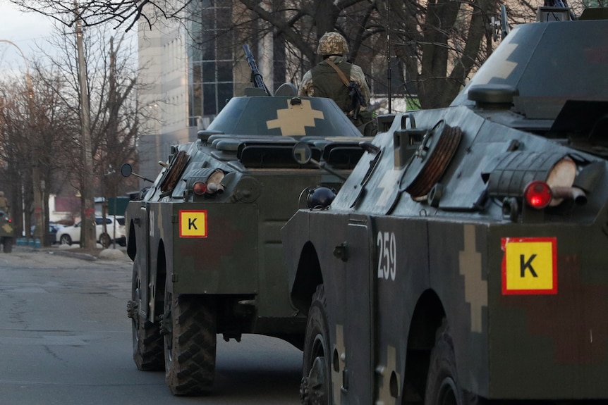 Ukrainian military personnel drive into Kyiv.