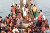 Rohingya migrants sit in a boat